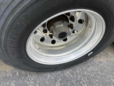 Wheel and tire close-up on a 2015 Utility 3000R trailer showing Michelin tire and polished steel wheel.