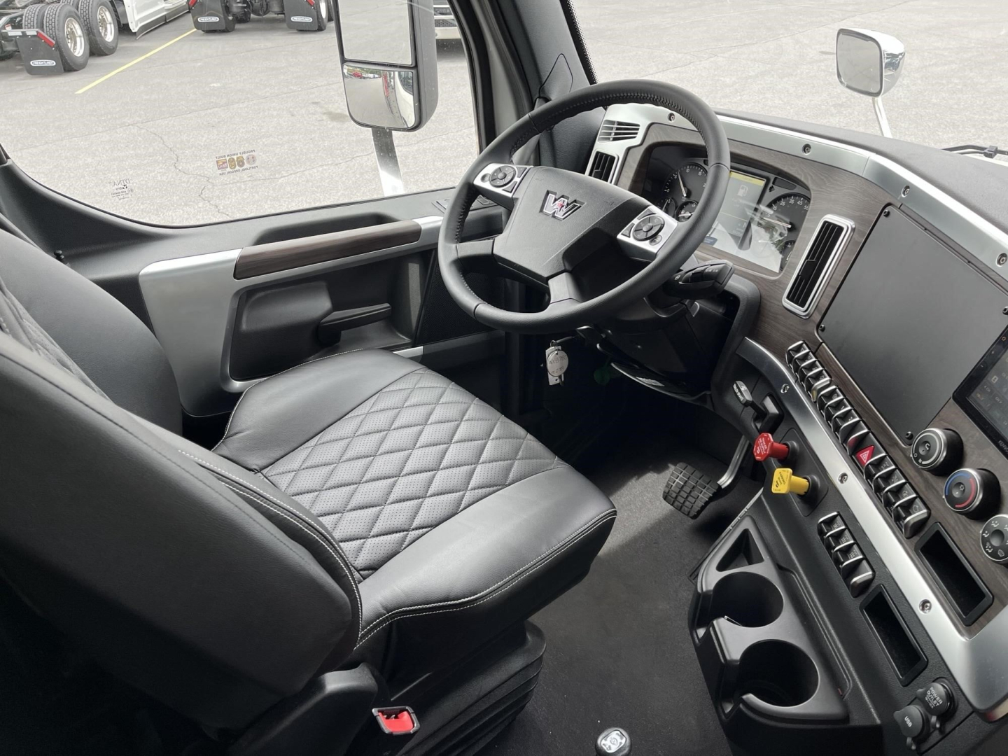 2027 Western Star 47X cab interior showing steering wheel, dashboard with controls, and quilted seat.