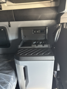 Cockpit area of a 2026 Mack PR64T76H truck showing center console with storage and USB/12V ports.