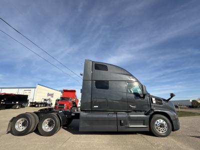 Mack PR64T76H conventional sleeper tractor side profile showing cab, tandem rear axles, and fuel tanks with clear Vista under bright sky.