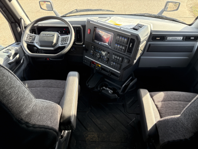 Mack PR64T76H truck interior showing steering wheel, dashboard, and center console with display screen.