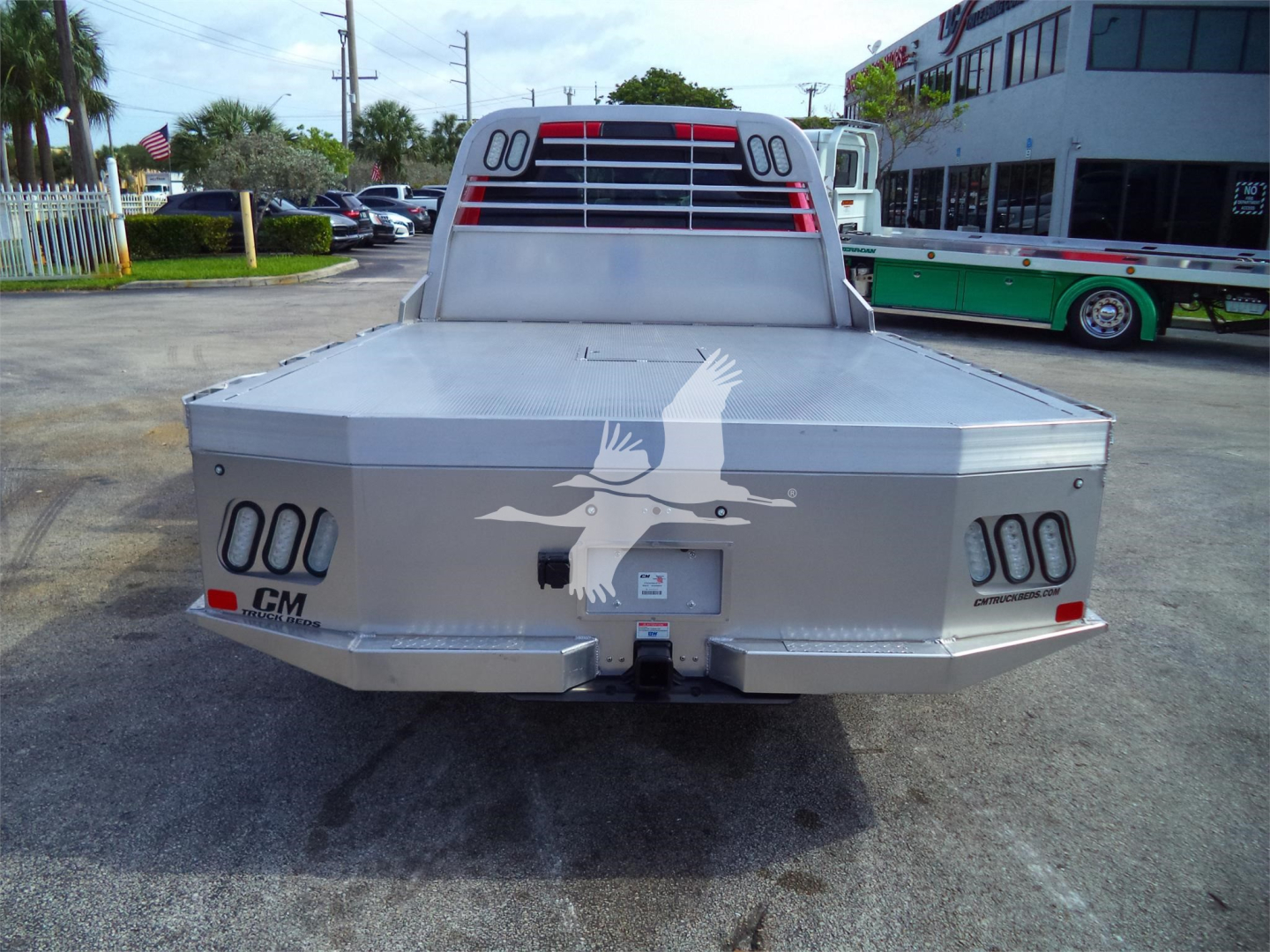 Ram 5500 flatbed truck rear view showing aluminum cargo bed and taillights with CM logo and a winged emblem.