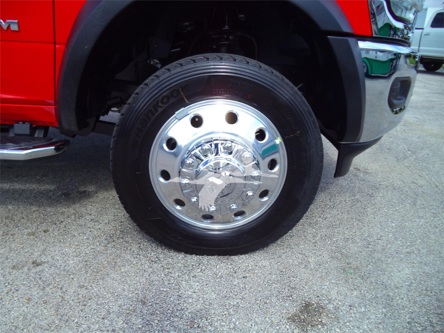 Ram 5500 front wheel with polished hubcap and tire; red fender and black fender flare visible