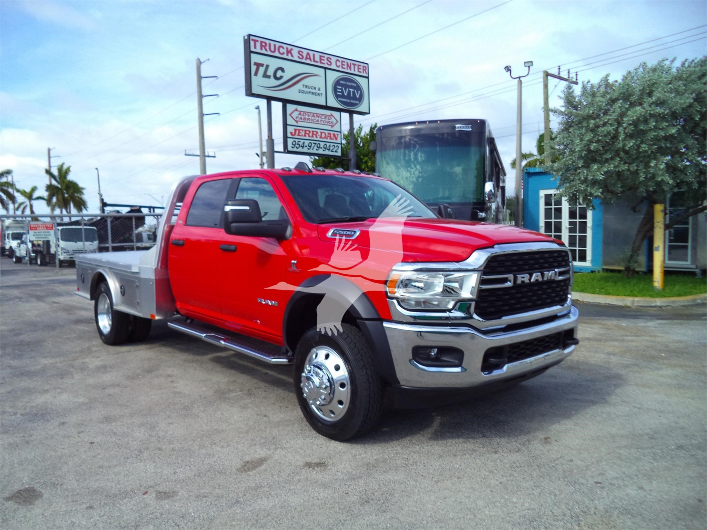 Red 2024 Ram 5500 SLT flatbed truck in a dealership lot, side view with dual rear wheels and chrome bumper.