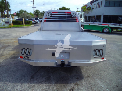 Ram 5500 flatbed truck rear view showing aluminum cargo bed and taillights with CM logo and a winged emblem.