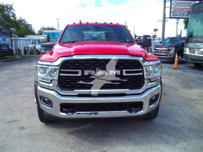 Ram 5500 front view showing large grille with DRW emblem and chrome bumper, red cab, dealership lot background.