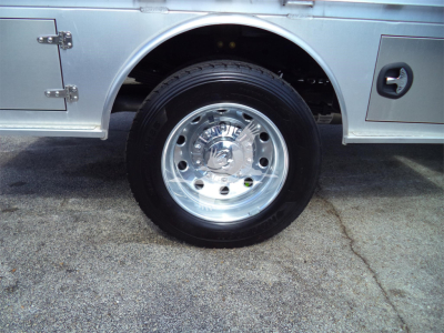 Ram 5500 SLT flatbed truck wheel and chrome hubcap showing tire and truck body panel details.