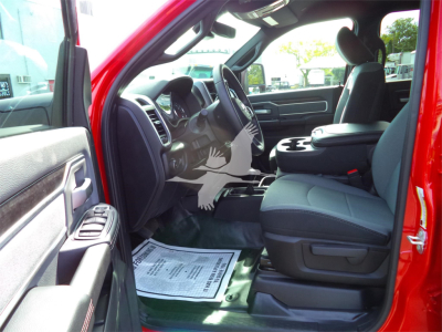 Interior of red Ram 5500 SLT crew cab showing front seats and dashboard from the driver’s side with open door; center console and floor mat visible.