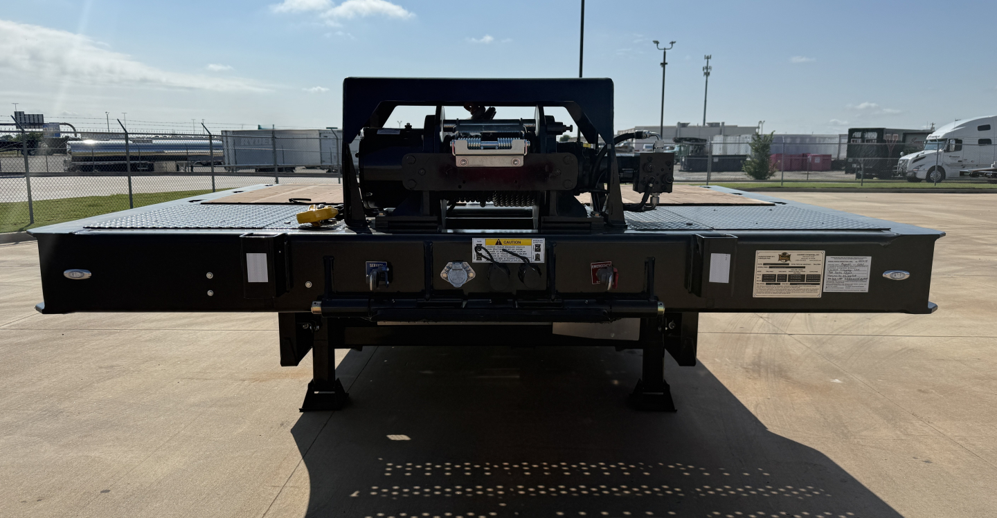 Landoll 455B-53 55 Ton traveling axle lowboy trailer hitch area with hydraulic components and label plates visible.