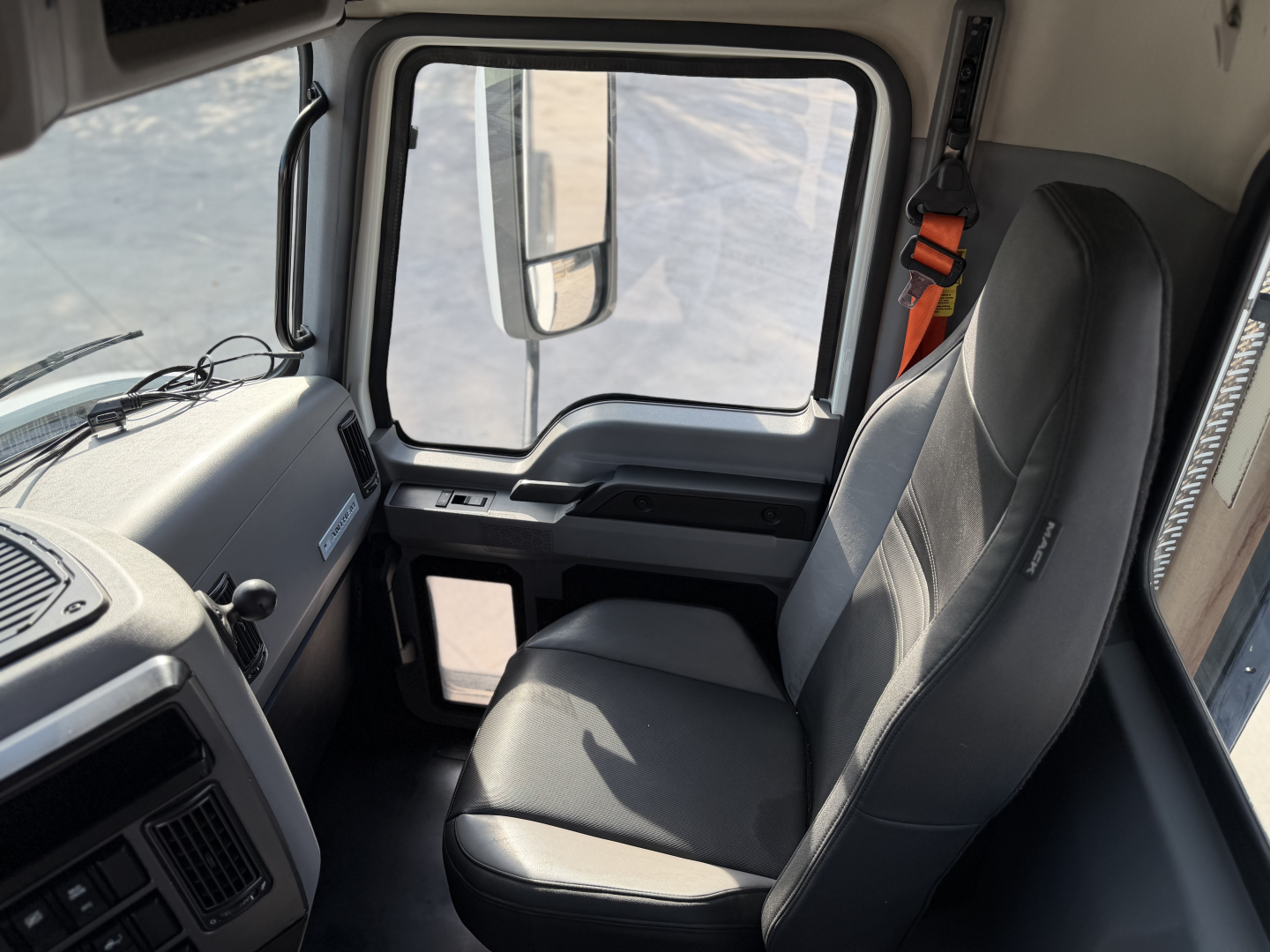 Cab interior of a 2023 Mack Anthem 64T tractor with black driver seat and dash area visible.