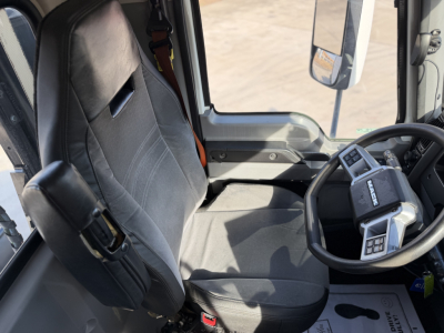 Truck cab interior of a 2023 Mack ANTHEM 64T showing the driver seat, steering wheel, and dashboard in view.