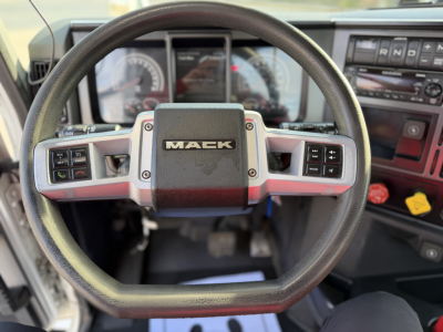 Steering wheel interior of a Mack truck showing the center badge and dashboard controls