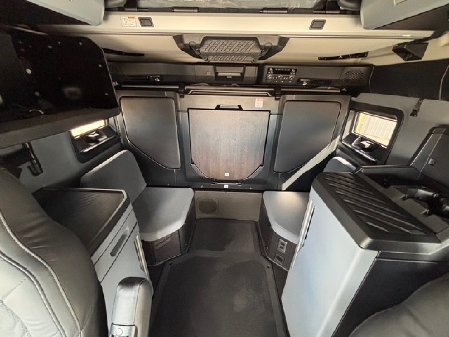 Cab interior of a new 2026 Mack PR64T76H sleeper tractor showing dashboard area, storage compartments, and seating in a modern truck cabin.