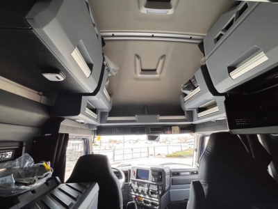 Cab interior of a 2026 Mack PR64T76H truck showing overhead storage compartments and dashboard dashboard with control panels.
