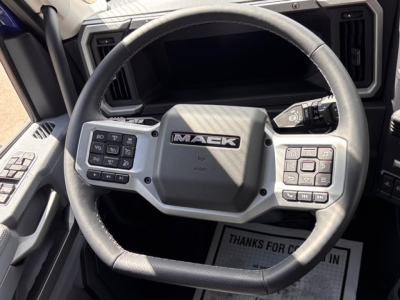Mack PR64T76H truck interior steering wheel with control buttons and dashboard visible.
