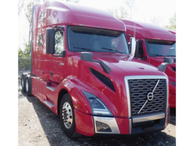 Volvo VNL 760 sleeper cab truck in red parked with chrome grille and headlights.
