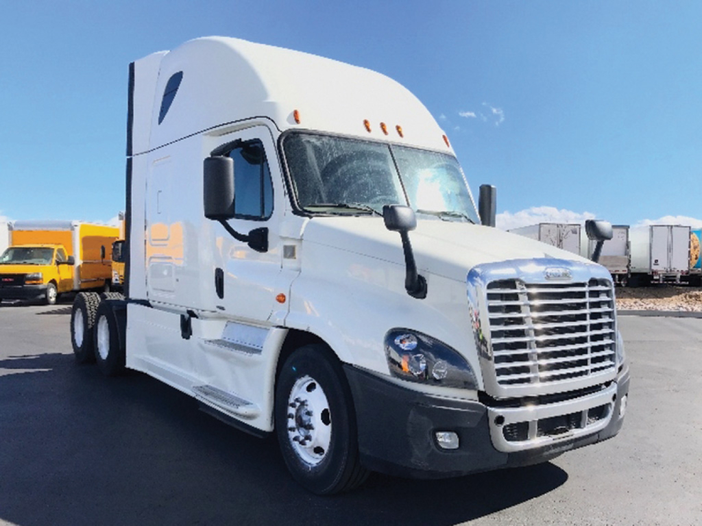 White Freightliner Cascadia Evolution semi-truck in a lot, front-right view, no visible branding text except the chrome grille.