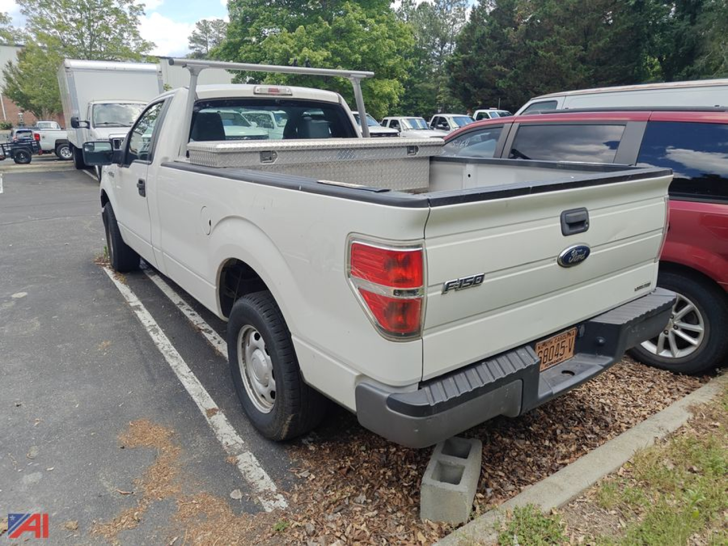 Ford F-150 pickup truck with a bed rack and toolbox, white color, 2013 model, in a parking lot.