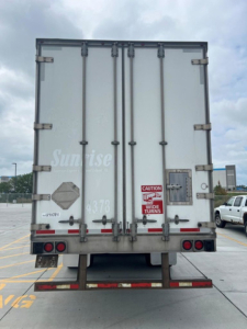 Rear view of a 2014 utility van/trailer showing double rear doors with latches, taillights, and caution labels on the right door. VIN and stock not visible.