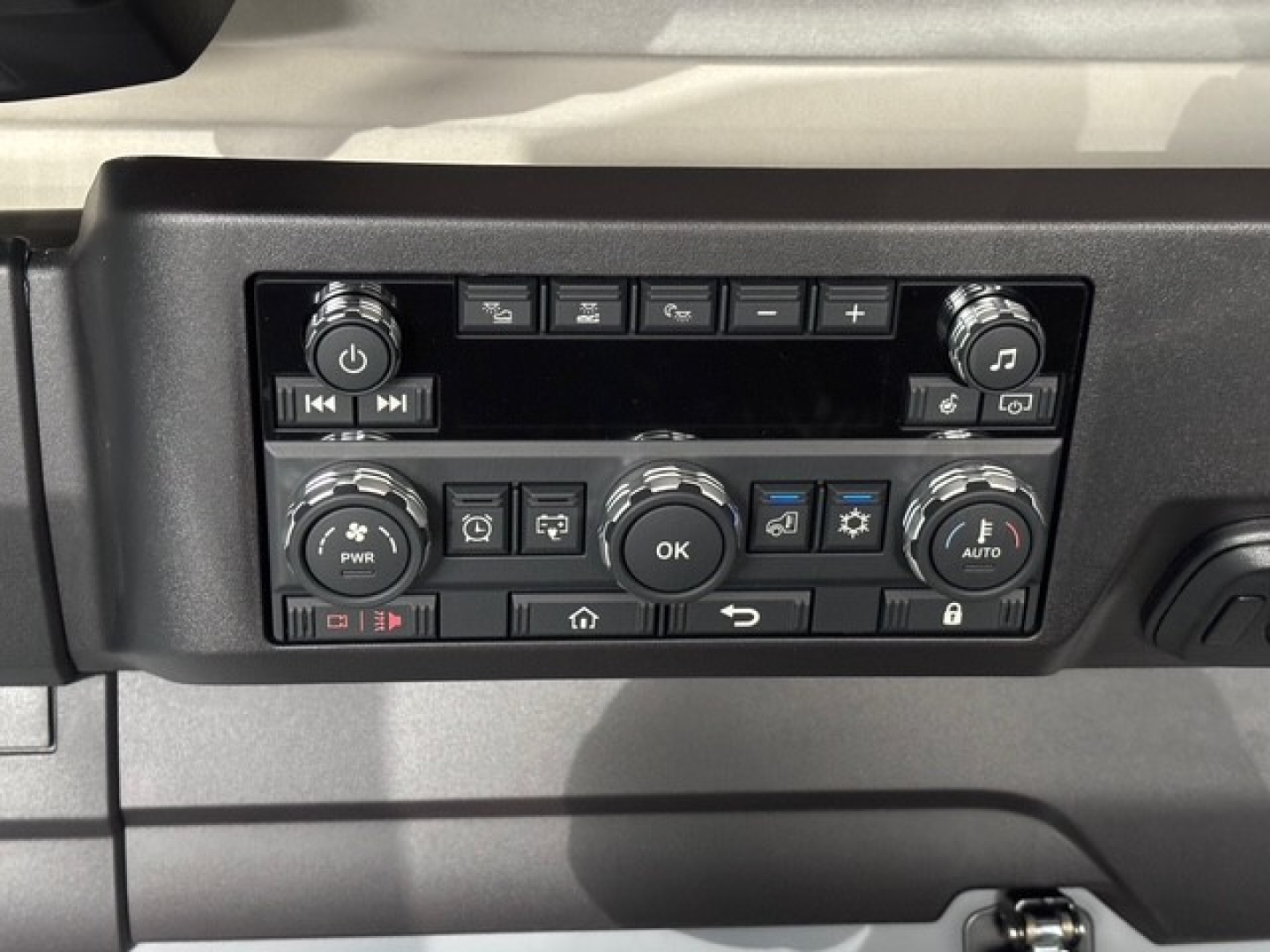 Cockpit dash panel of a 2026 Mack PR64T76H truck showing numerous controls and knobs in a symmetric layout.