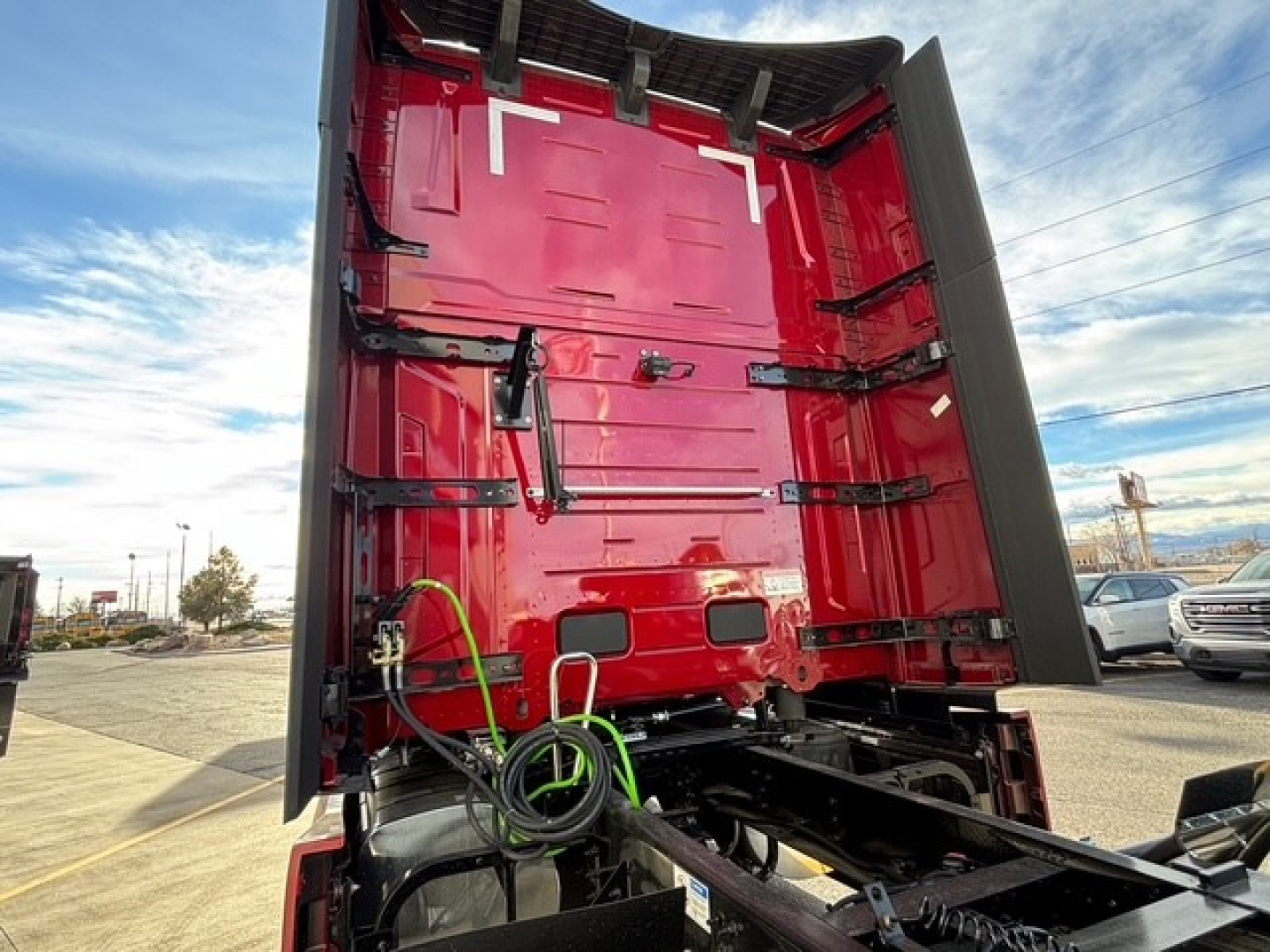 Mack PR64T76H conventional sleeper truck viewed from rear with open trailer hitch area and red cab interior.