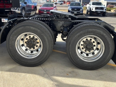 Front side view of a Mack PR64T76H semi truck chassis showing dual rear axles with polished aluminum wheels and large tires.