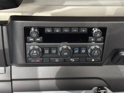 Cockpit dash panel of a 2026 Mack PR64T76H truck showing numerous controls and knobs in a symmetric layout.