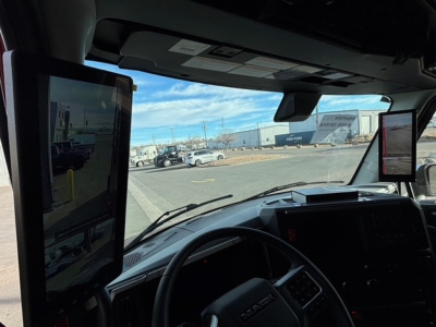 Mack PR64T76H truck cabin interior showing large vertical screen monitor on driver side and dashboard controls.