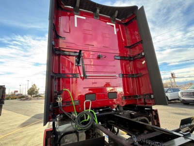 Mack PR64T76H conventional sleeper truck viewed from rear with open trailer hitch area and red cab interior.