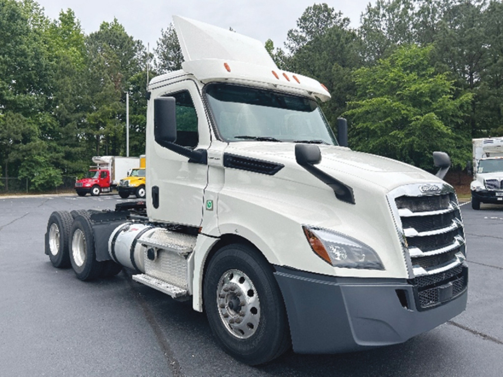 Truck cab of a 2019 Freightliner Cascadia126 daycab seen from front-left angle with white paint and black grille