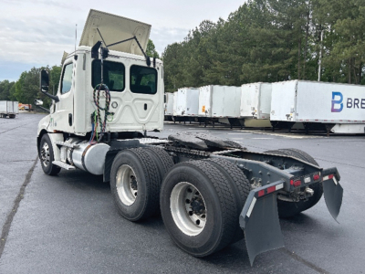 Truck chassis and cab of a Freightliner Cascadia126 with sides and rear view. Shows dual rear axles, exposed frame, and parts of the cab interior through the window.