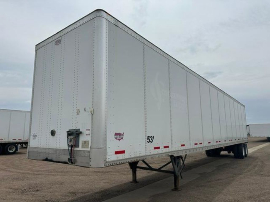Trailer side view showing a 53' white Wabash dry van trailer with rear swing doors and registration decals.