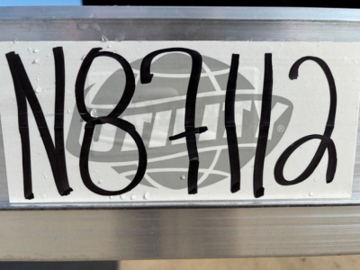Trailer VIN N87112 tag on metal frame showing N87112. Droplet-free metal surface with stamped numbers.