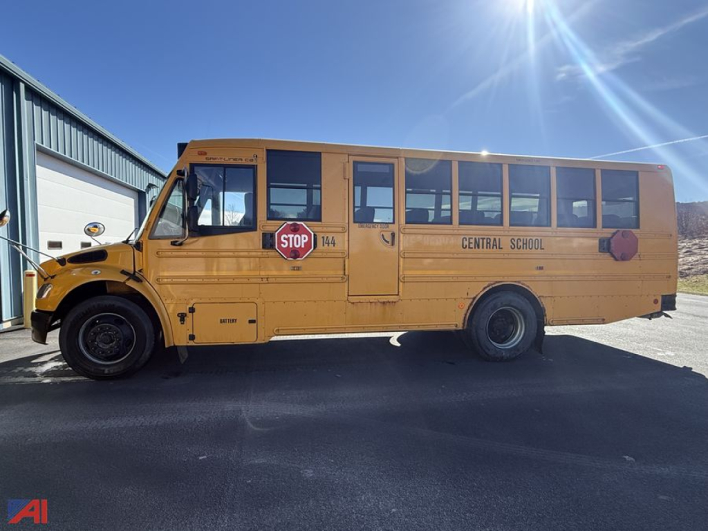 School bus side view showing Central School with stop sign, yellow body, D-Series chassis, blue sky.