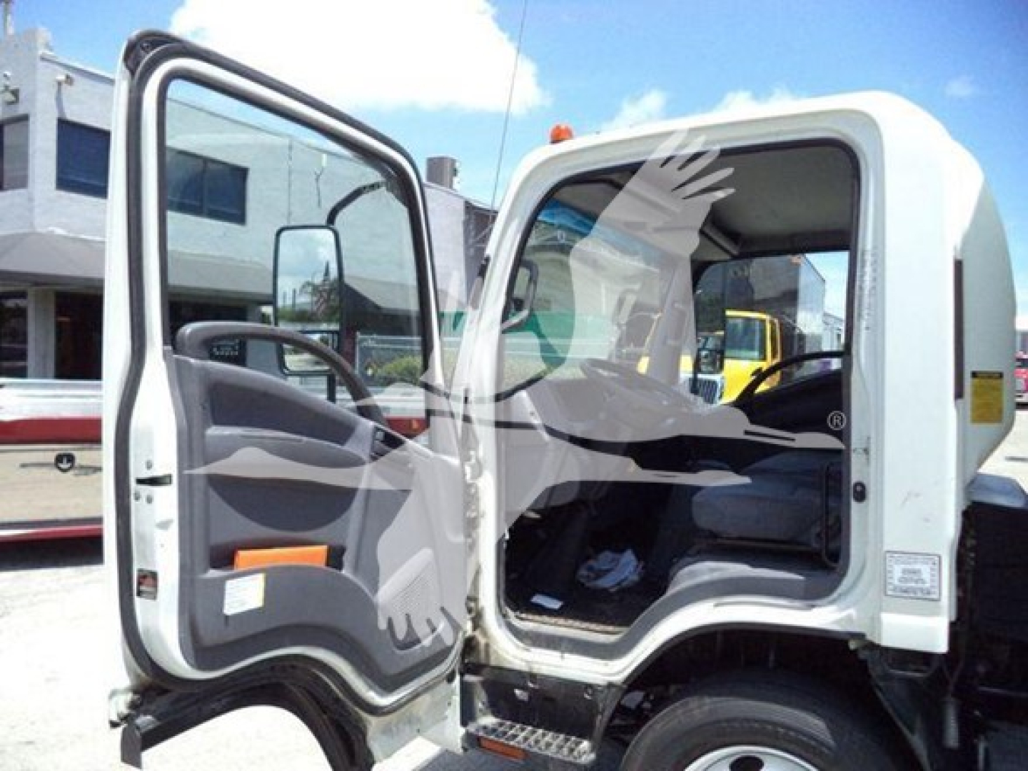 Isuzu NPR box truck cab interior with driver door open showing gray dashboard, steering wheel, and seating area.