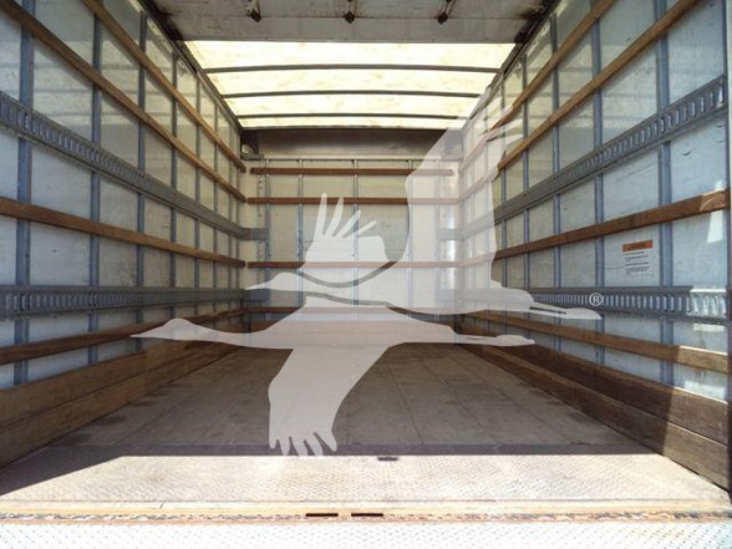 Isuzu NPR box truck cargo area with empty wooden floor and sidewall rails viewed from rear cargo bay.