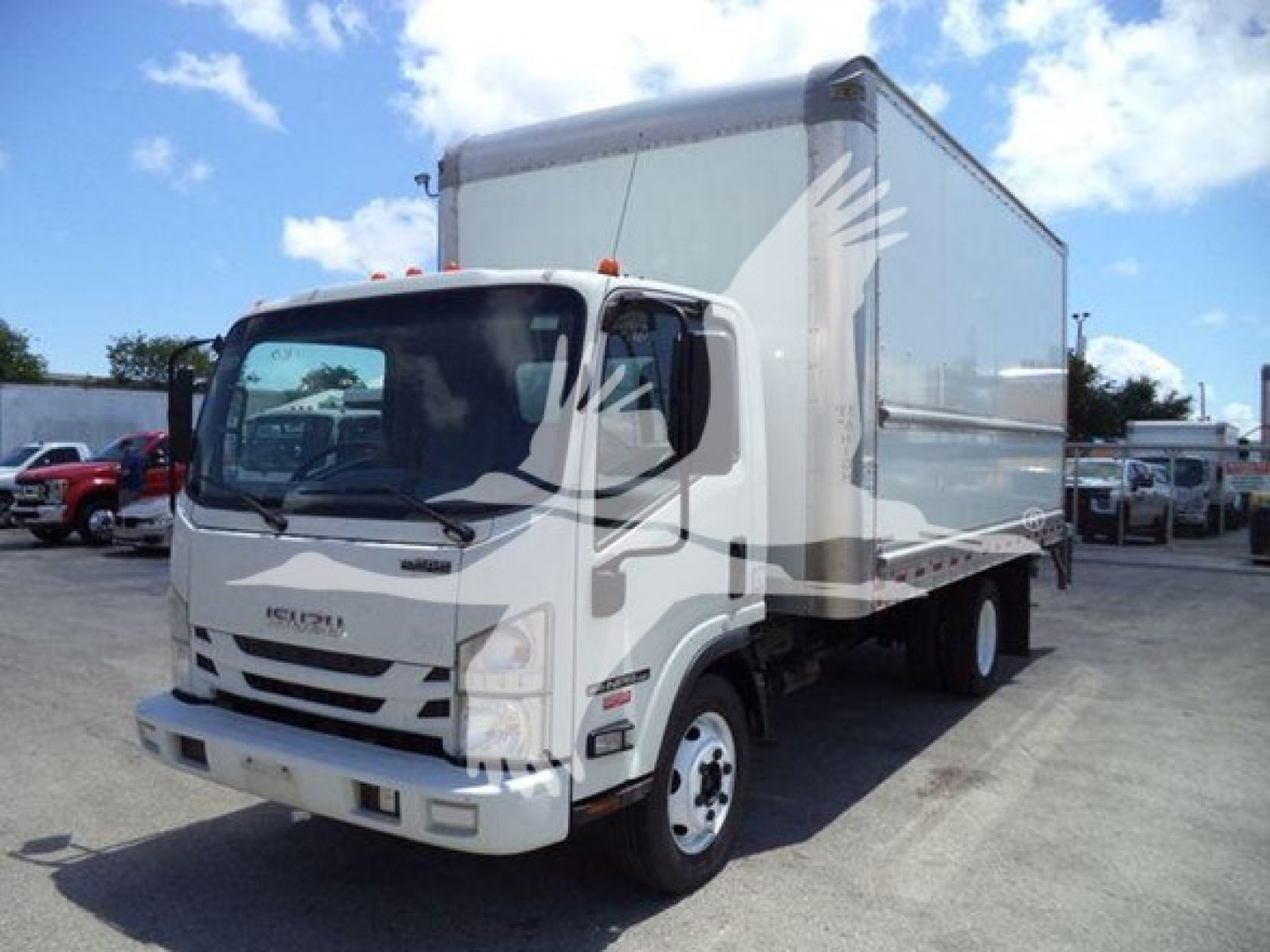 Isuzu NPR box truck in view showing front and right side, white cab, large box body, stock number T09759.