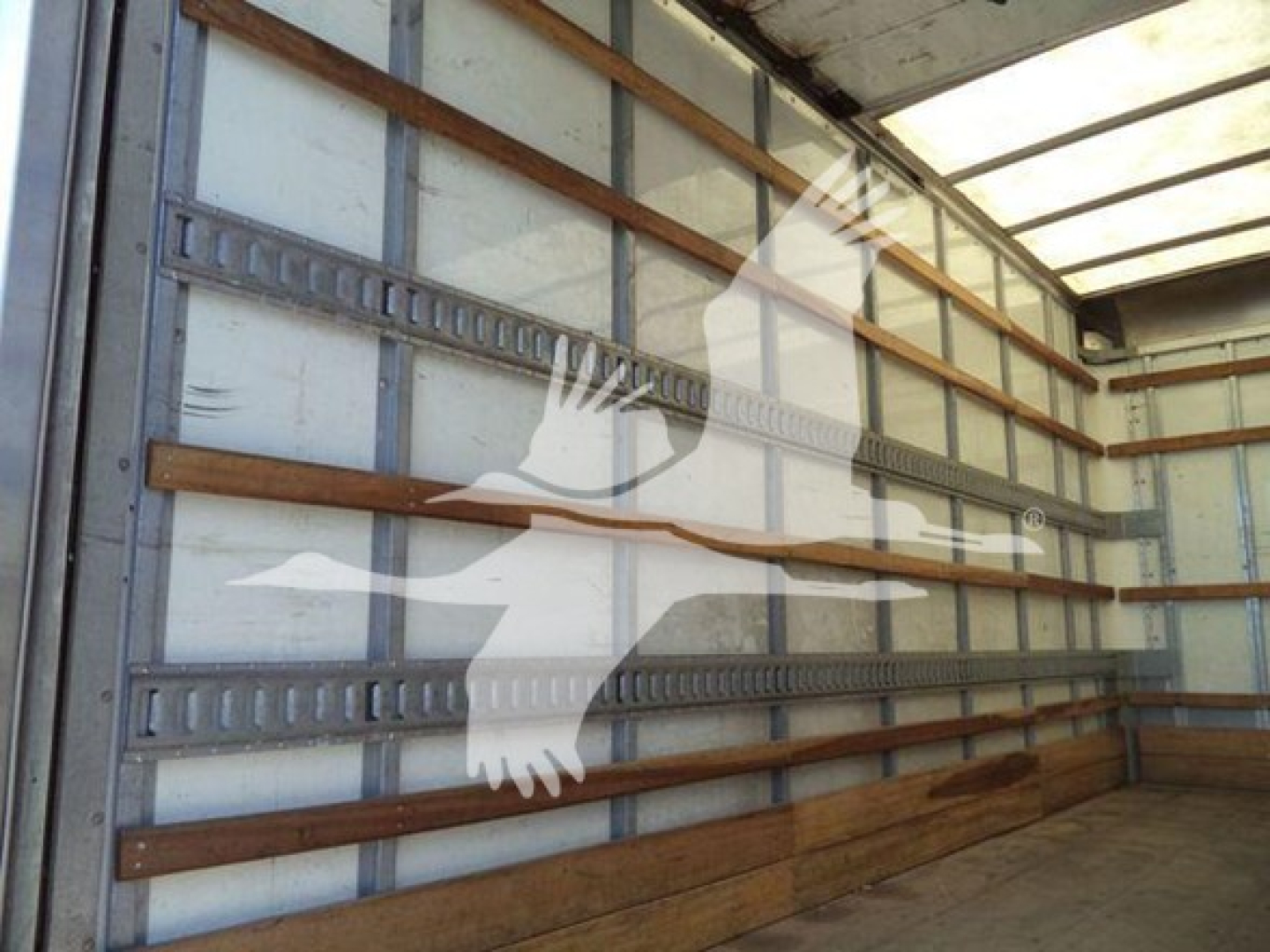 Isuzu NPR box truck interior showing empty cargo area with metal side rails and wooden floor.