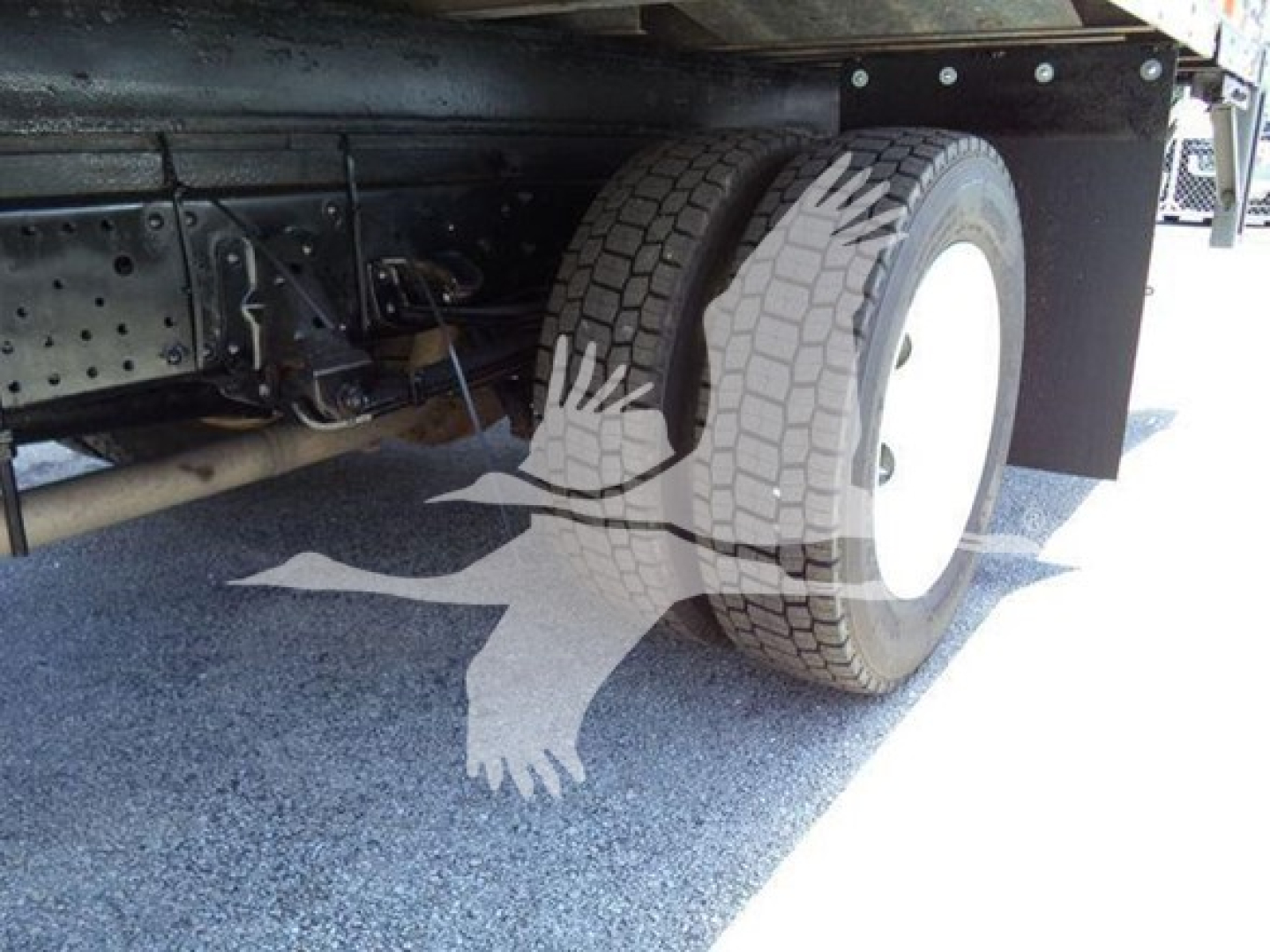 Rear section of Isuzu NPR truck showing dual rear tires and underbody components.
