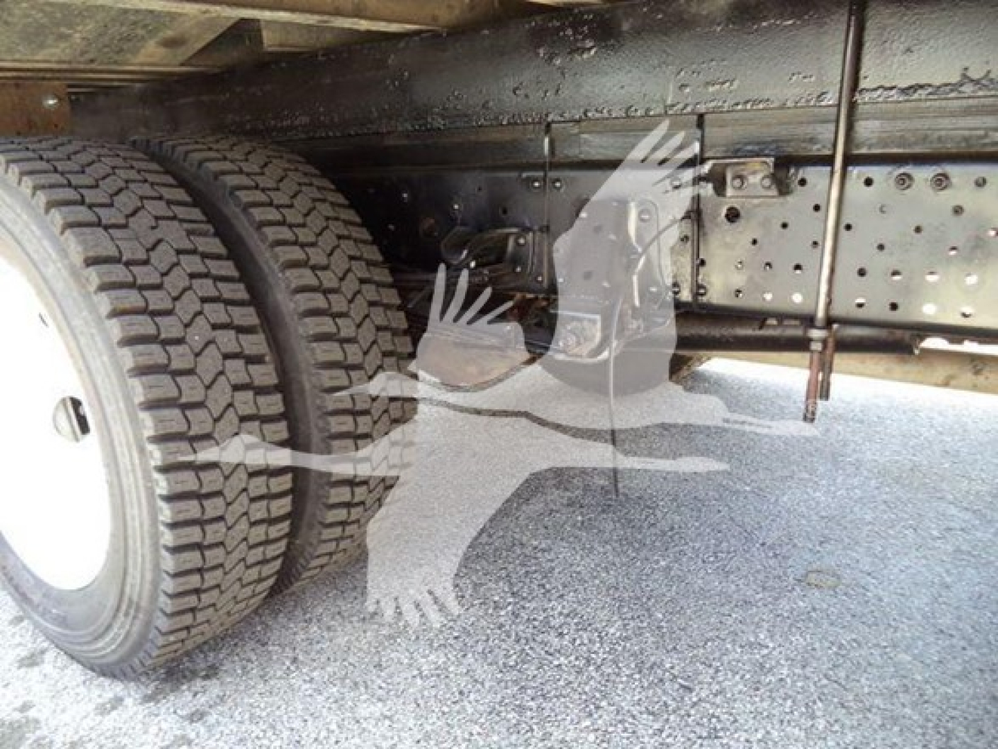 Isuzu NPR truck chassis and dual rear wheels under carriage showing undercarriage frame and tires.