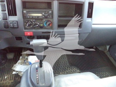 Isuzu NPR dashboard and gear shifter area showing center console controls and empty radio slot.