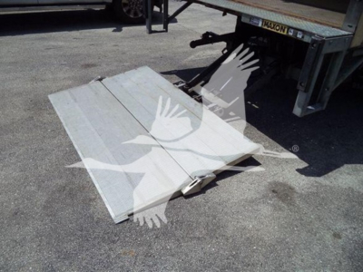 Ramp and liftgate platform showing alloy trailer ramp with hinge and support beneath Isuzu NPR truck.