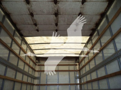 Truck cargo area interior showing metal ribs and empty box with overhead roof; no legible labels visible.