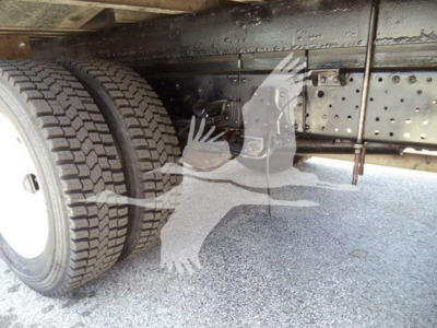 Isuzu NPR truck chassis and dual rear wheels under carriage showing undercarriage frame and tires.