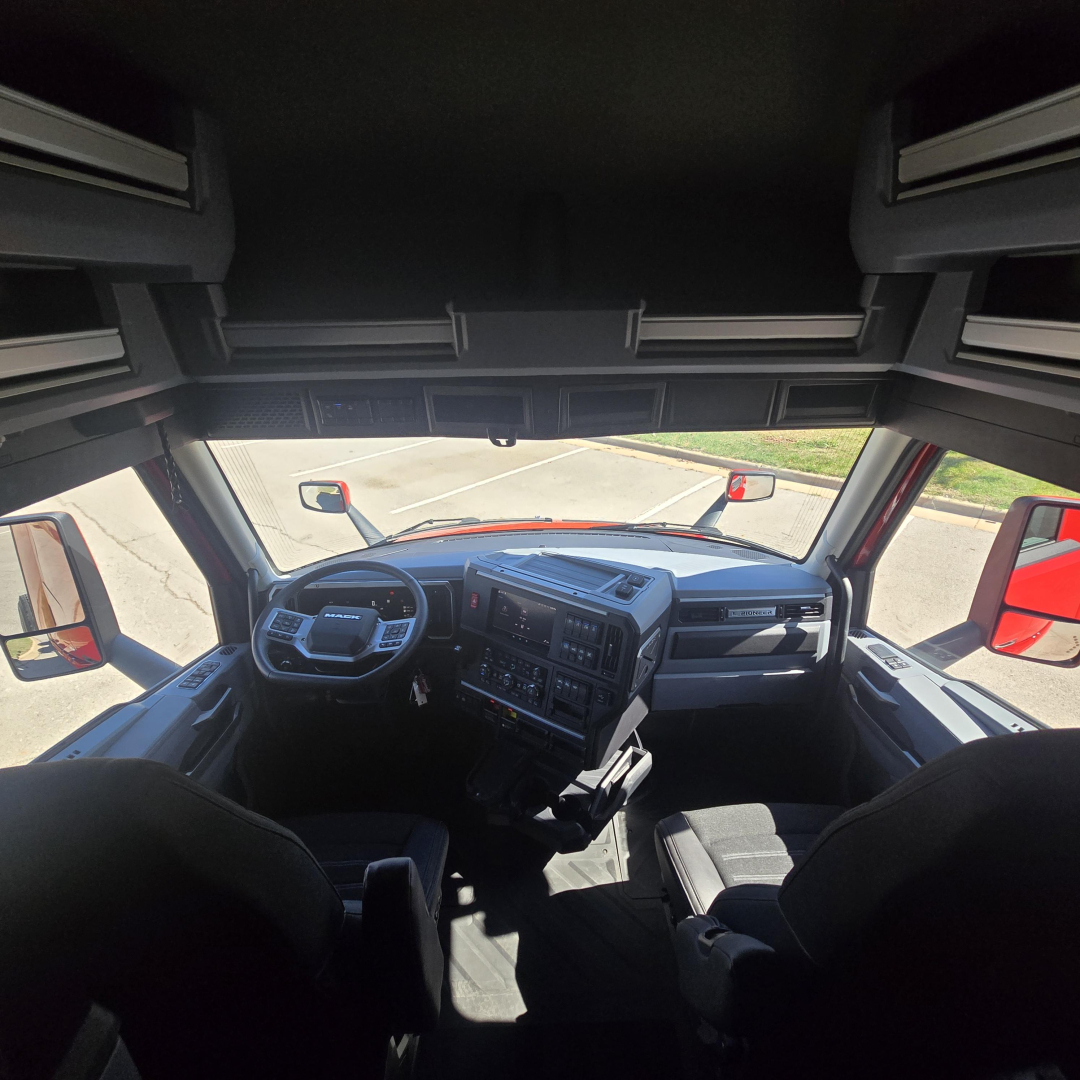 Interior cab view of a 2026 Mack PR64T76H truck showing dashboard, steering wheel, and driver seat.