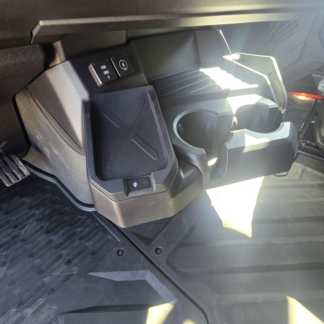 Cab interior showing center console area with cup holders and storage beneath dashboard in a Mack PR64T76H truck.