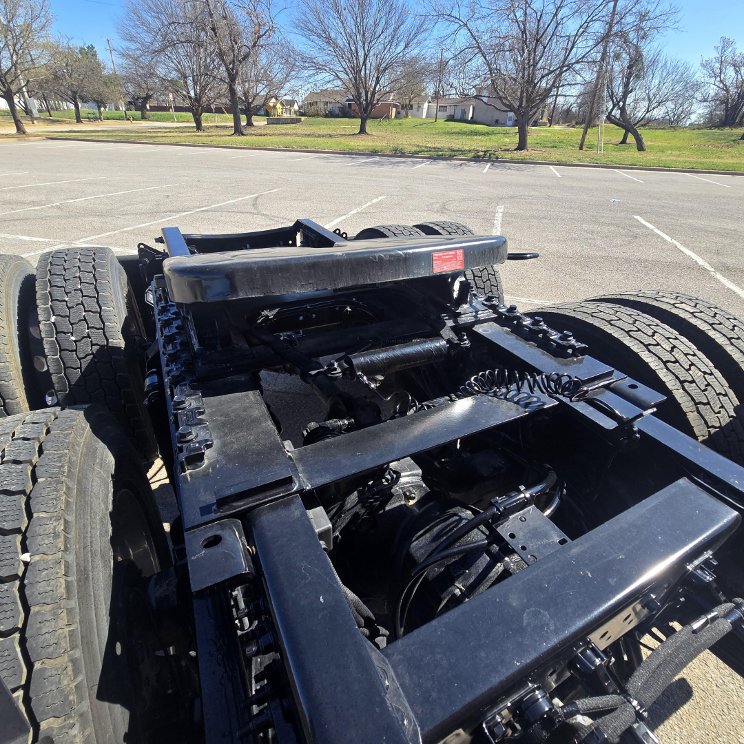 Chassis view of a 2026 Mack PR64T76H truck showing the frame, drive axles, and suspension components from an elevated angle.