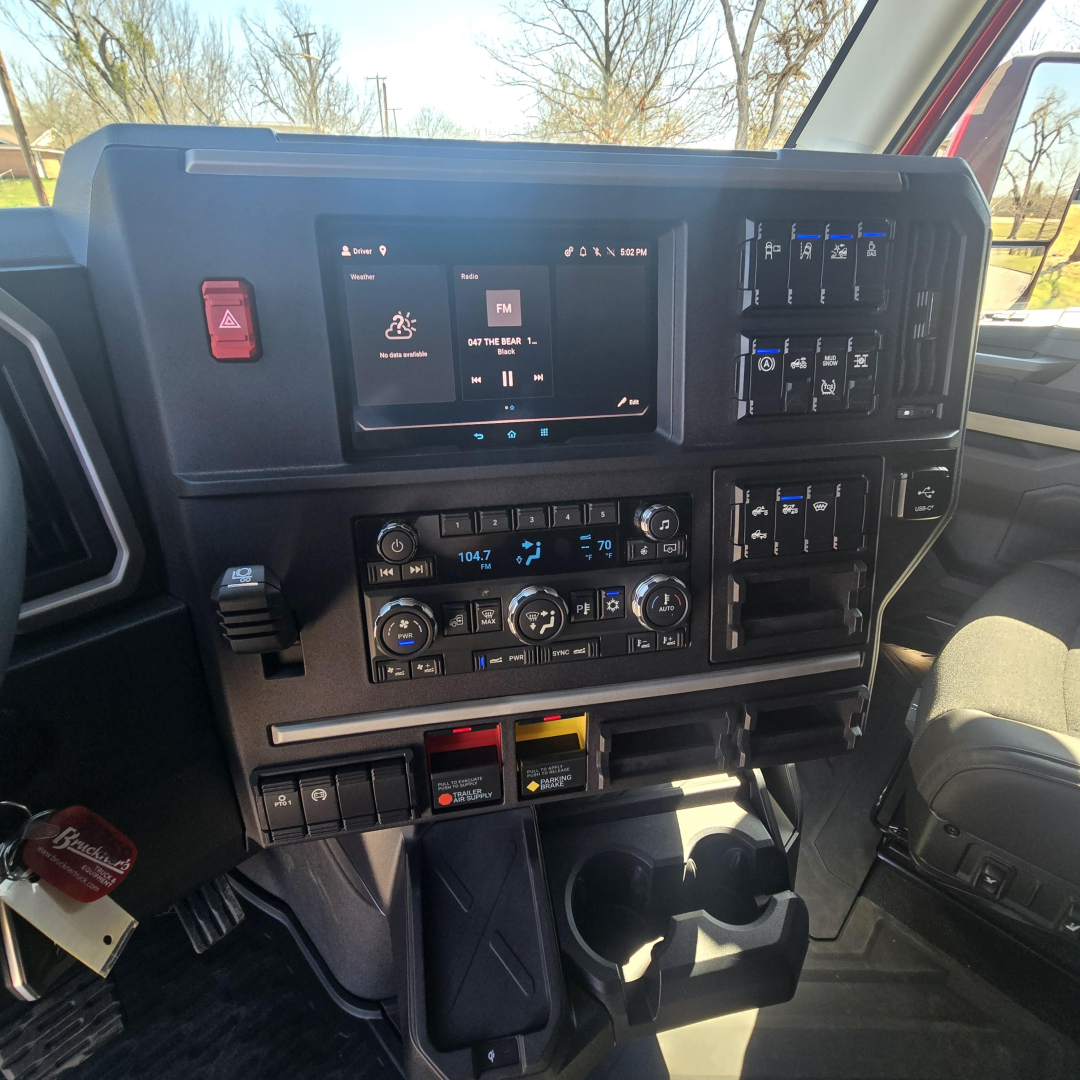 Dashboard of a 2026 Mack PR64T76H truck showing center touchscreen, climate controls, and various switches and cup holders.