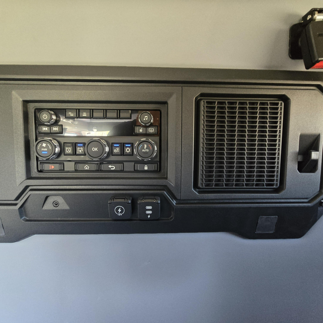 Dashboard control panel with climate controls and vent on Mack PR64T76H interior,” showing buttons and knobs.