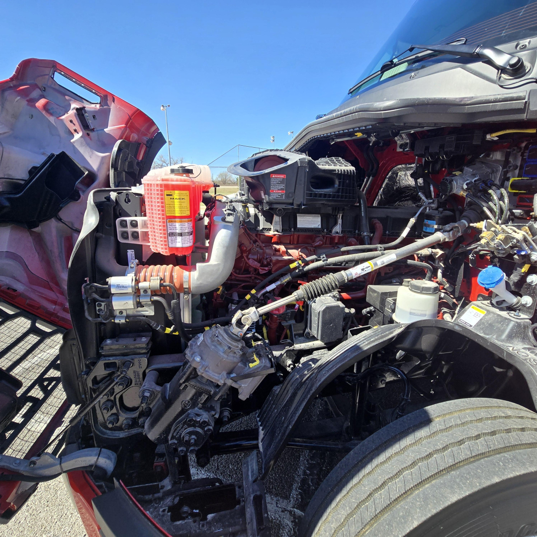 Engine bay of a 2026 Mack PR64T76H conventional sleeper showing fluid reservoirs and engine components.